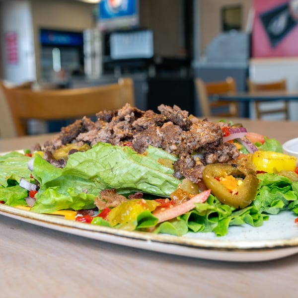 A Home Run Burger salad with ground beef, lettuce, tomatoes, onions, and jalapeños.