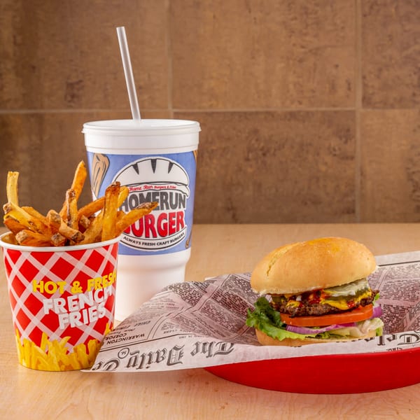 A Home Run Burger combo with a burger, fries in a red cup, and a drink.