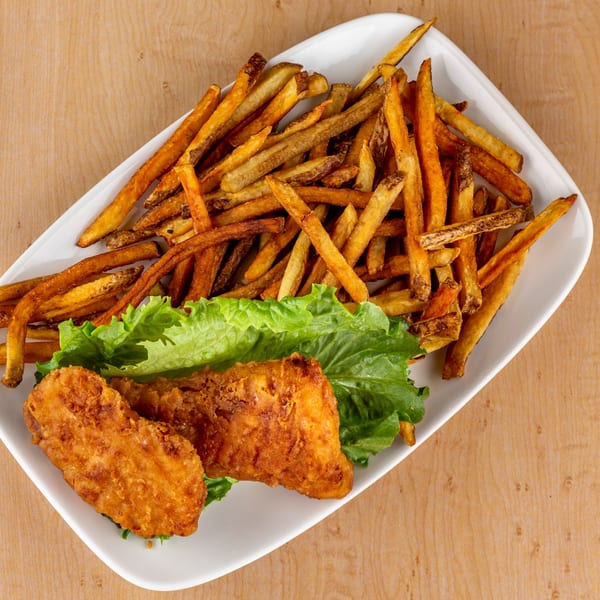 Crispy fried chicken tenders and golden french fries served on a bed of fresh lettuce.