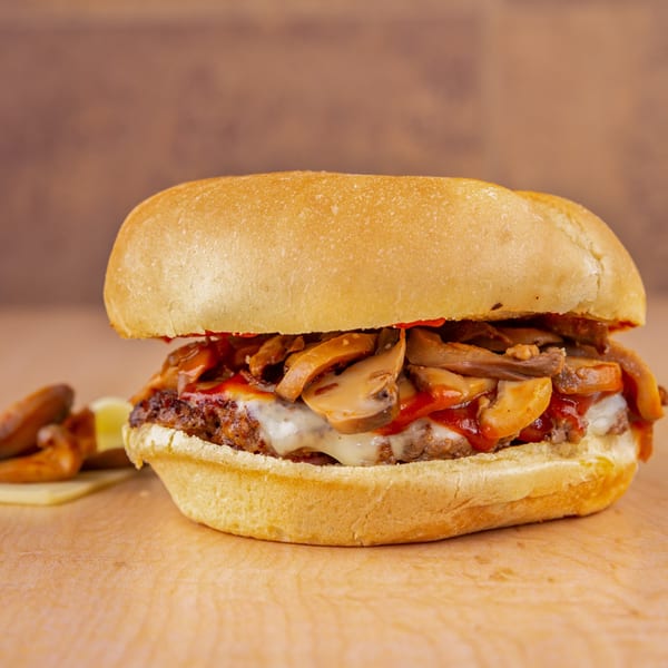 Home Run Burger's mushroom burger with melted cheese and red sauce, served with fries.