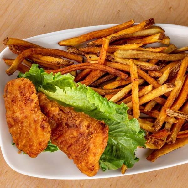 Crispy fried chicken tenders on a bed of lettuce with a side of golden-brown french fries.