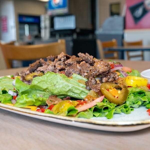 A Home Run Burger salad with ground beef, lettuce, jalapenos, and other toppings.