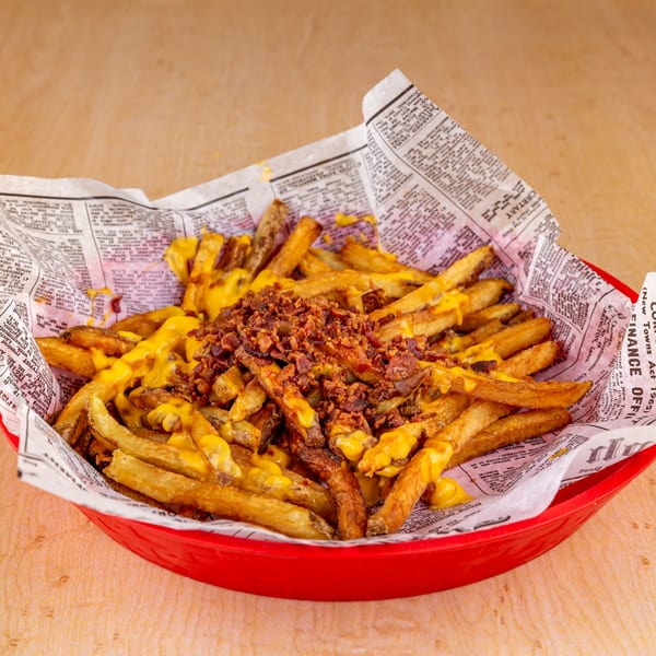 Home Run Burger's cheesy bacon fries, served in a red basket lined with newspaper.